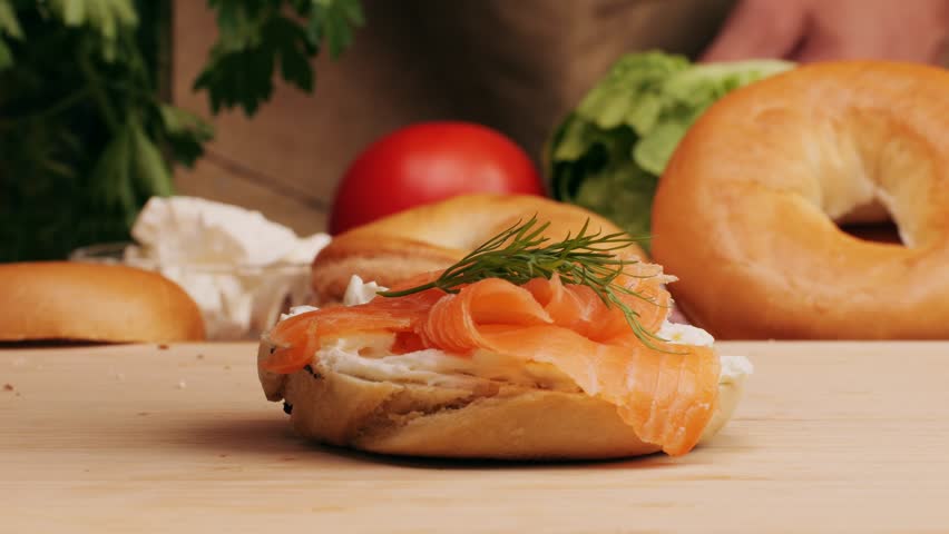 Bagel sandwich brunch, lunch plate of a bagel with smoked salmon and cream cheese and ham, close up morning cafe menu.