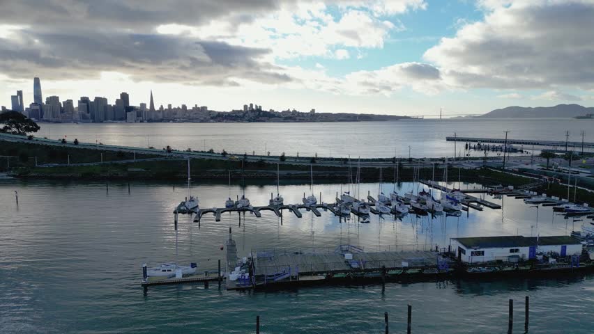 A smooth horizontal side-tracking drone shot of Treasure Isle Marina on Yerba Buena Island, CA. It highlights the marina, boats, and scenic shoreline, perfect for travel, marine, or coastal footage.