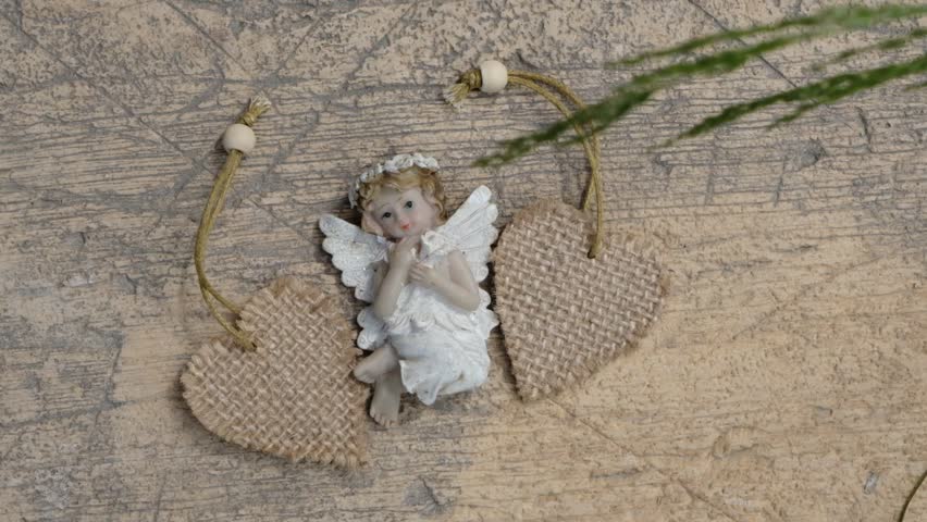 Close-up two heart, angel and grass shadow swawing by the wind on the brown beige concrete wall or floor with textured pattern, morning sunlight.