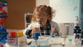 Funny schoolgirl surprised by unexpected chemical reaction, looking into flask - Powered by Shutterstock - Get 15% off with code: PIKWIZARD15