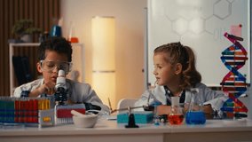 Two schoolchildren doing a lab project in science class, looking in microscope - Powered by Shutterstock - Get 15% off with code: PIKWIZARD15