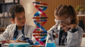 Schoolgirl examining sample under microscope, boy writing down test result - Powered by Shutterstock - Get 15% off with code: PIKWIZARD15