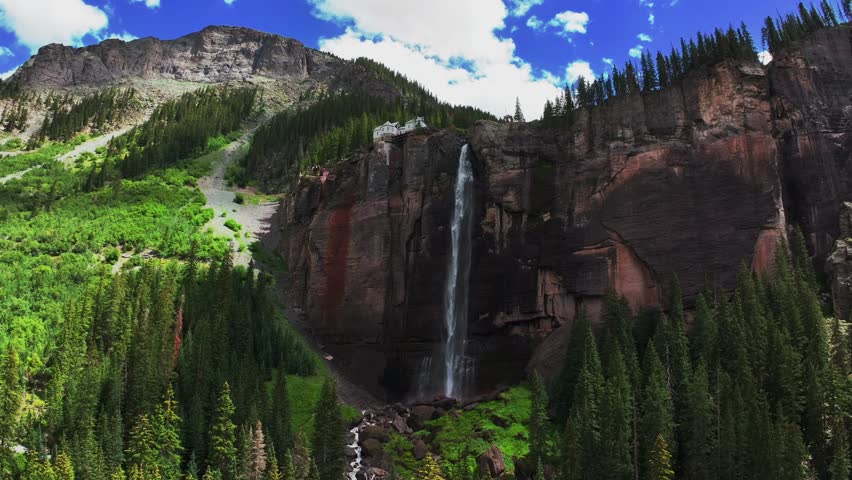 Telluride Bridal Veil Falls Waterfall Colorado powerplant house aerial drone sunny summer green Box Canyon Black Bear Pass Road Rocky Mountains 4wd blue sky cliffside Uncompahgre Forest circle left