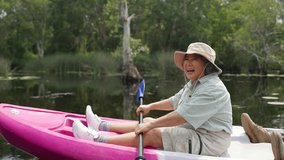 Happy Asian family senior couple kayaking in the river on summer holiday vacation. Healthy elderly people enjoy and fun outdoor active lifestyle travel nature, sport and rowing a boat in the lake. - Powered by Shutterstock - Get 15% off with code: PIKWIZARD15