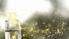 Animation of shooting stars and confetti falling over close up of hand holding a champagne glass. Party and celebration concept - Powered by Shutterstock - Get 15% off with code: PIKWIZARD15