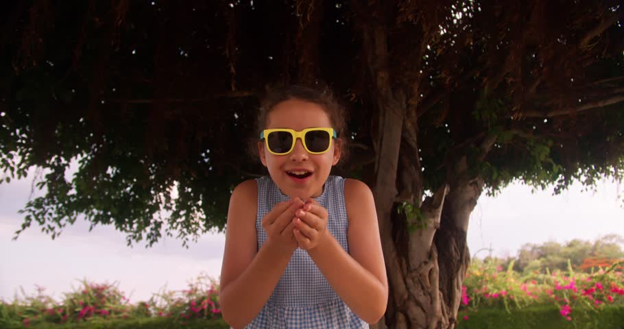 Portrait an excited young boy on a playground throwing confetti in air and laughing.