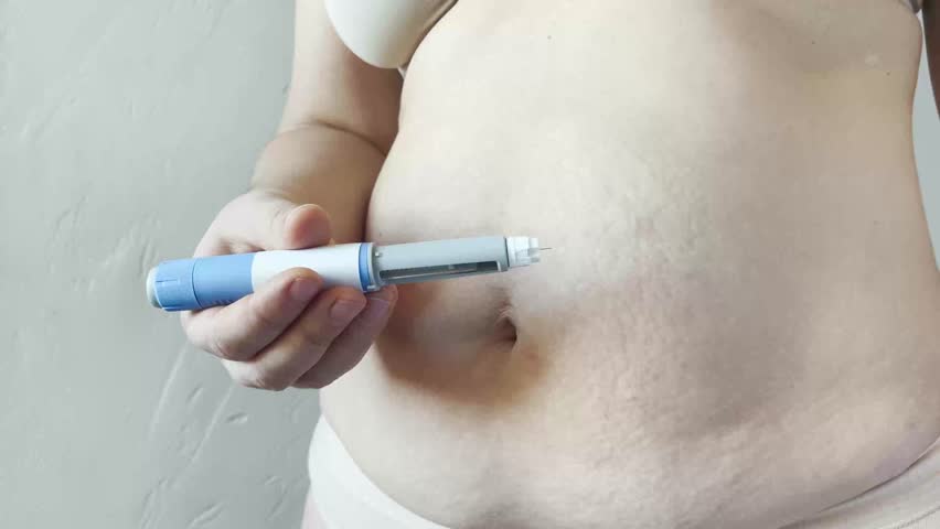 Woman making Semaglutide Injection closeup. Semaglutide or insulin Injection pen in female belly. Semaglutide Diabetes Drug Being Used For Weight Loss. 
