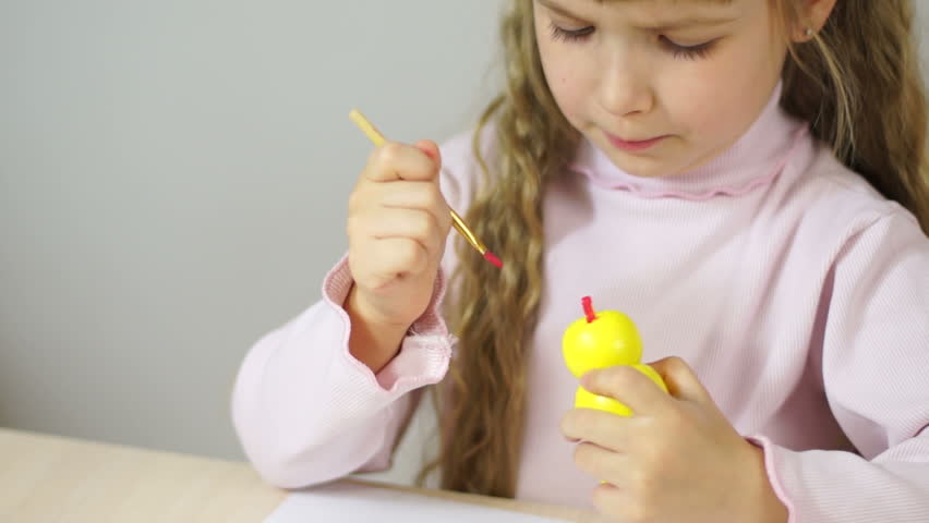 Baby girl paint the wooden figure toy. Fine Art lesson