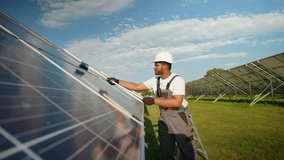 Indian worker washing solar panels with a cleaning tool - Powered by Shutterstock - Get 15% off with code: PIKWIZARD15