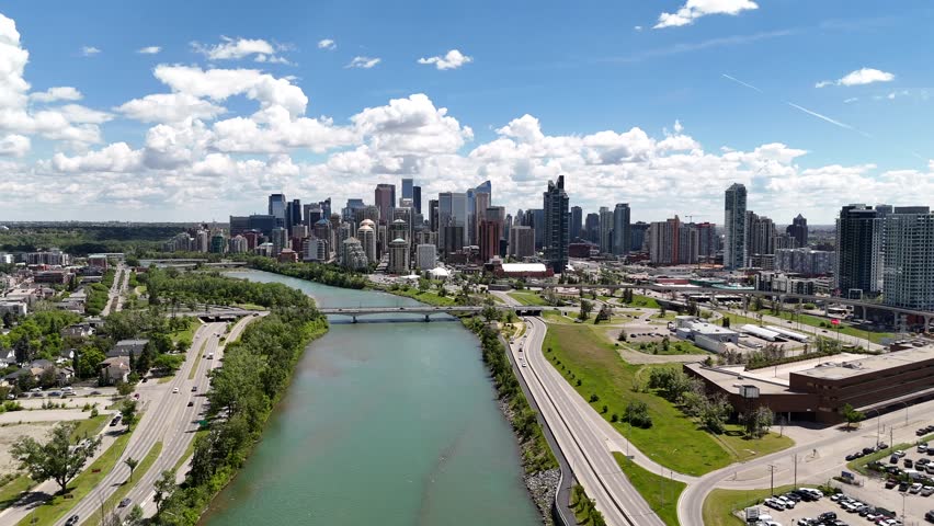 Aerial downtown city skyline with bridge revealing a river flowing between roadways in Calgary Alberta Canada.
