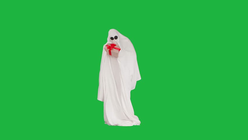 Halloween ghost in white sheet happy moving and holding gift box, isolated on chroma key green screen background, full length. Spooky concept.