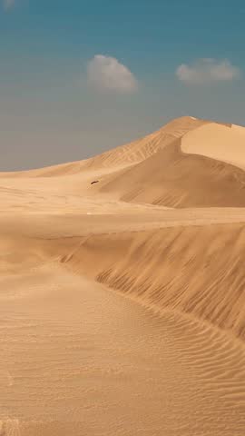 Desert at daytime, golden hue before the sun rises over Sealine Desert dunes and inland lake with its long curving beach, Doha, Qatar.