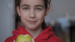 Portrait of Teenage Girl with Blue Eyes Eating Green Apple. Child Eats Fruit. Kid Bites Fruit and Chews Looking at Camera in Kitchen. Diet Vegetarian Healthy Nutrition Happy Child Biting Eating Apple. - Powered by Shutterstock - Get 15% off with code: PIKWIZARD15