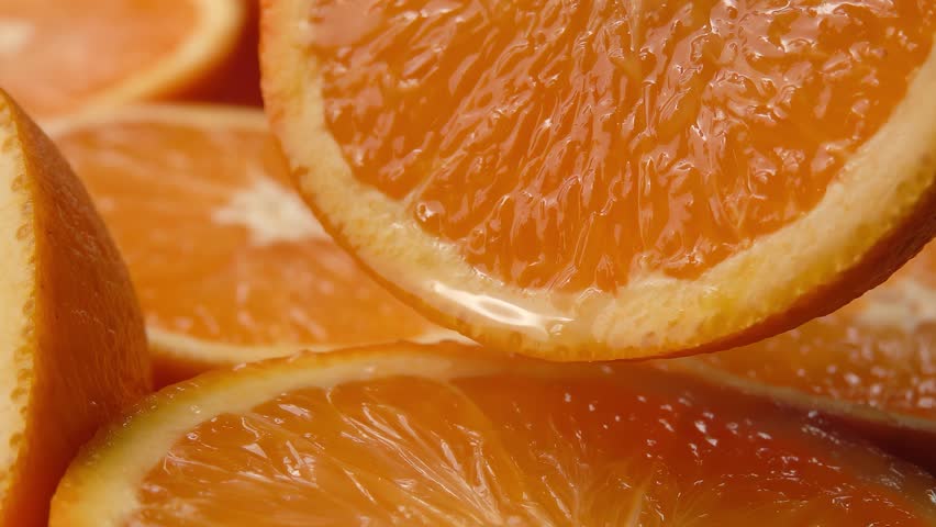 Orange juice is poured over half an orange fruit. High quality 4k footage