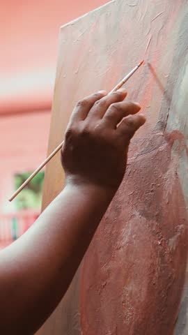 Vertical Video Male artist painting a modern artwork with watercolor and palette, working on his new creation in art and craft workshop. Young painter creating a rustic masterpiece on canvas. Camera B