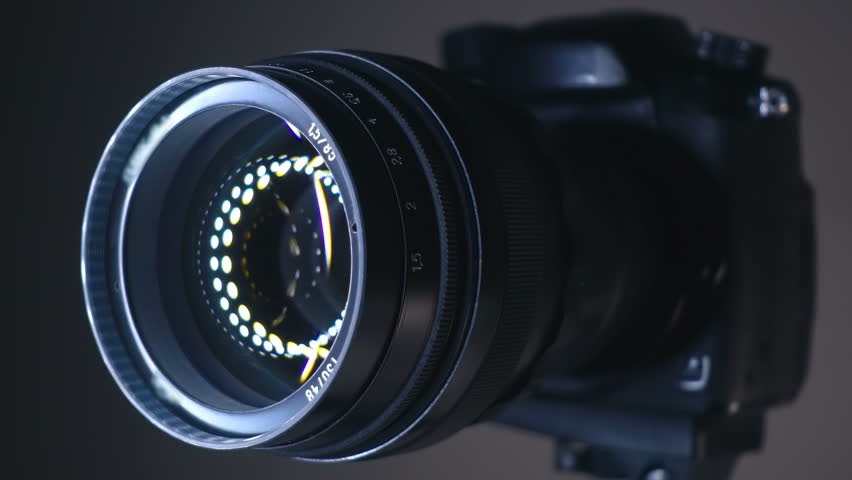 A professional camera on a tripod with an expensive lens with an aperture of 1.5 and a focal length of 85 mm, which reflects the ring LED light. Closeup. Macro