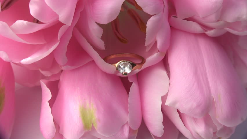 Gold ring with a gemstone inside the fresh and delicate flower tulip