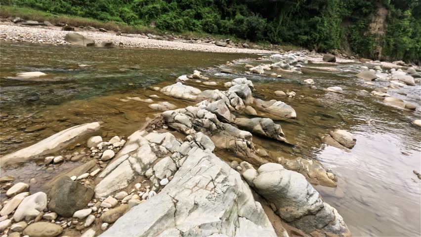 Clear stream running through stone boulders Abundant river flowing on stone bottom in slow motion. Wild mountain river water splashing in summer day bubbles. Beautiful View of Scenic Winding River