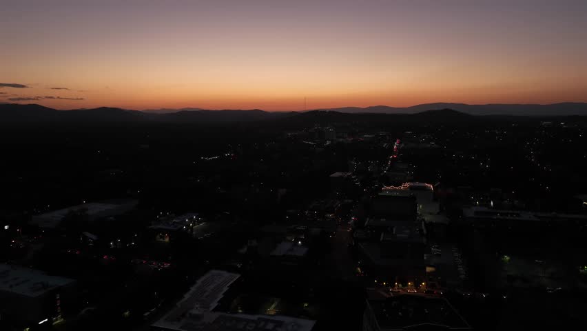 Aerial descending shot of small American town after golden sunset. Dusk scene in USA Housing area. Wide shot.