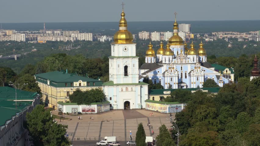 Ukraine,Kyiv,St.Michael Cathedral, footage shows the whole complex with golden domes and the bell tower surrounded by lush green and the city behind it with a perfect angle, traffic in the front moves