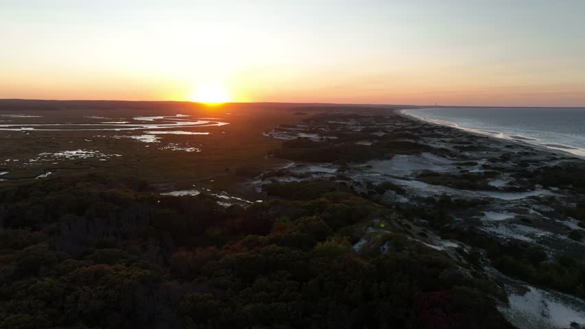 Static aerial view of sunset at Salt Marsh and sand dunes at Cape Cod, Barnstable Massachusetts. Sunset at horizon.