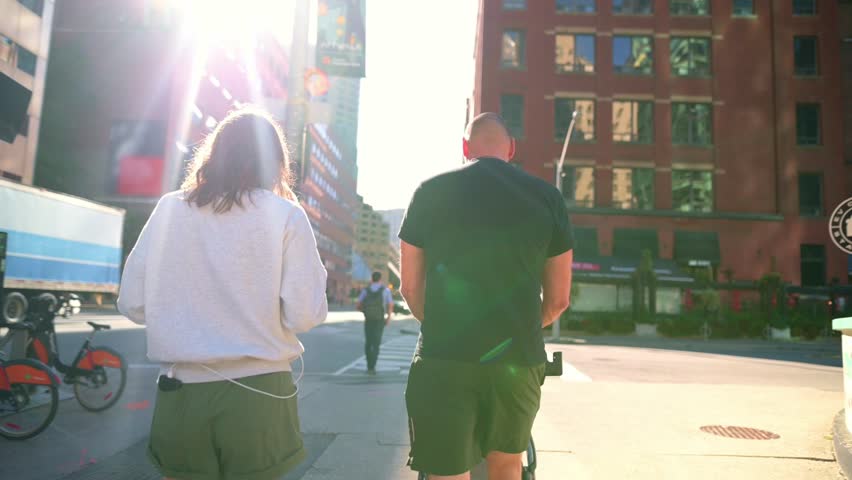 group of people casually walking along a street in downtown Toronto, surrounded by urban buildings and bright sunlight. walking along a street in downtown Toronto, People walking in downtown