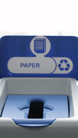 Close up of man putting a receipt into a paper recycling bin, recycling failure. Media. Concept of wrong recycled garbage, bad for the environment.