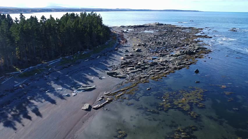 Panoramic aerial view of Pointe-Leggatt on the St. Lawrence River. Picturesque beach where sand and intriguing geological formations intertwine in a calm bay. Quebec, Canada, 2024.
