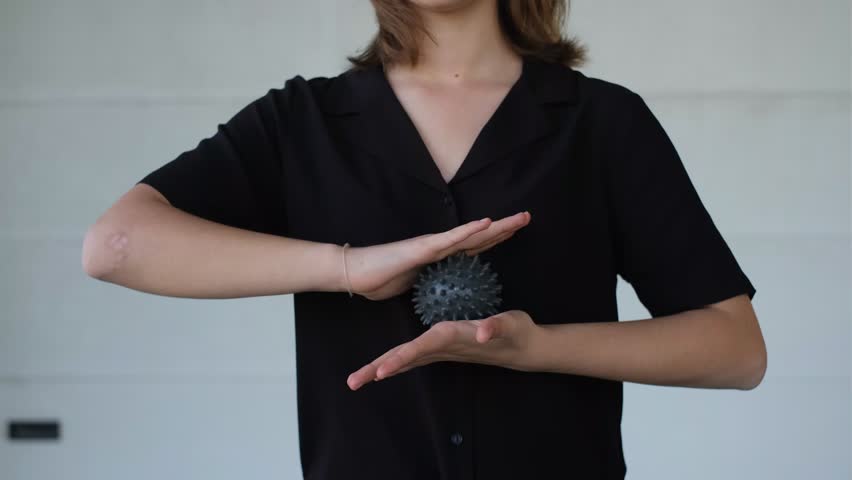 a young beautiful woman massages her hands with a massager with a ball with spikes