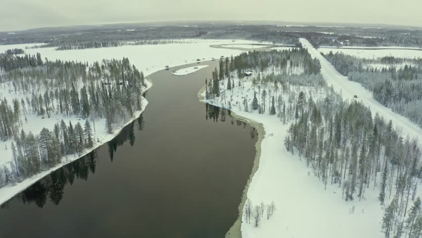 Experience the tranquil beauty of a snowy river landscape featuring tall pine trees and winding banks, capturing the essence of winter in a remote wilderness area.	