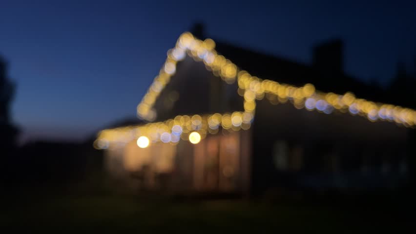 blurred house decorated with Christmas lights, filmed during the evening