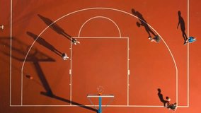 Aerial view of a basketball court in slow motion, capturing players and their shadows moving across the court. Concept of sports, teamwork, and dynamic urban recreation. Young men shoot the basket - Powered by Shutterstock - Get 15% off with code: PIKWIZARD15