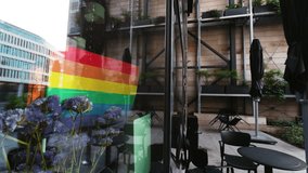 A serene urban reflection at a modern cafe with rainbow flag and floral decor, reflecting diversity and a colorful community ambiance - Powered by Shutterstock - Get 15% off with code: PIKWIZARD15