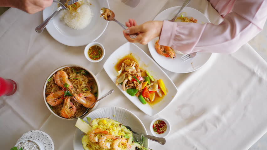 Happy Asian family senior couple having lunch and sharing meal together at restaurant. Elderly people man and woman enjoy retirement with outdoor activity lifestyle on summer holiday travel vacation.