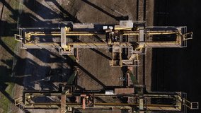Aerial view of an industrial facility showcasing rusted metal structures, tracks, and shadows. - Powered by Shutterstock - Get 15% off with code: PIKWIZARD15