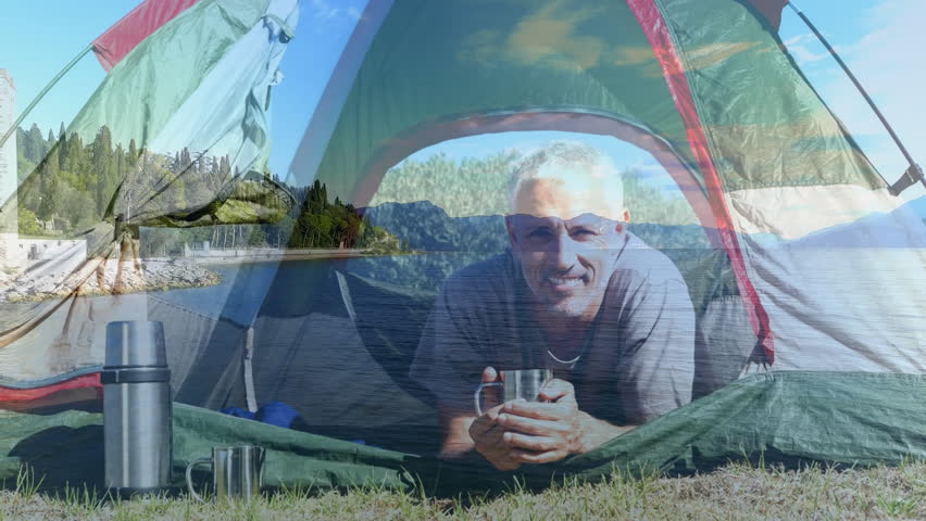 Camping in tent, man holding cup over scenic lake and forest landscape. outdoors, adventure, nature, travel, hiking, relaxation