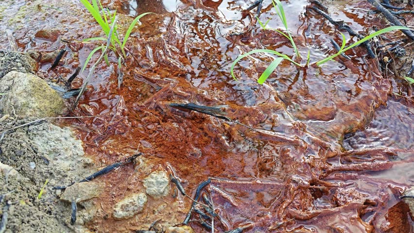 leaking water flowing into the muddy soil.