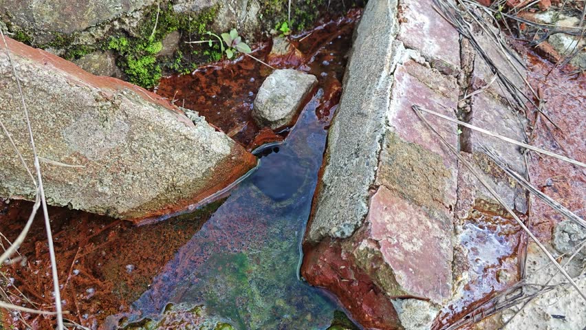 leaking water flowing into the muddy soil.