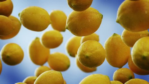 Lemons with water droplets falling down in front of blurry background. Slow motion CG animation. Stockvideó