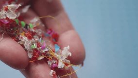 In slow motion, microplastic particles trickle from fingers, vividly portraying environmental pollution and sample testing. - Powered by Shutterstock - Get 15% off with code: PIKWIZARD15