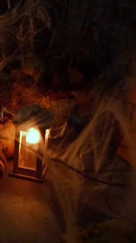 Dark room with candles, spiders, webs and a human skull. Horrible atmosphere of horror, ghosts, spirits and scary stories. Halloween decorations