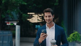 Positive Bearded Businessman Going Around the City and Watching Funny Videos on Smartphone while Coffee Break. Happy Young Man Using the Mobile Phone and Walking to the Office. People and Technology - Powered by Shutterstock - Get 15% off with code: PIKWIZARD15