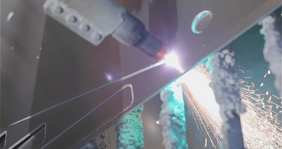 The plasma cutter will cut the part. Plasma cutting. Plasma cutter work at the factory. The process of cutting a metal part with a plasma cutter