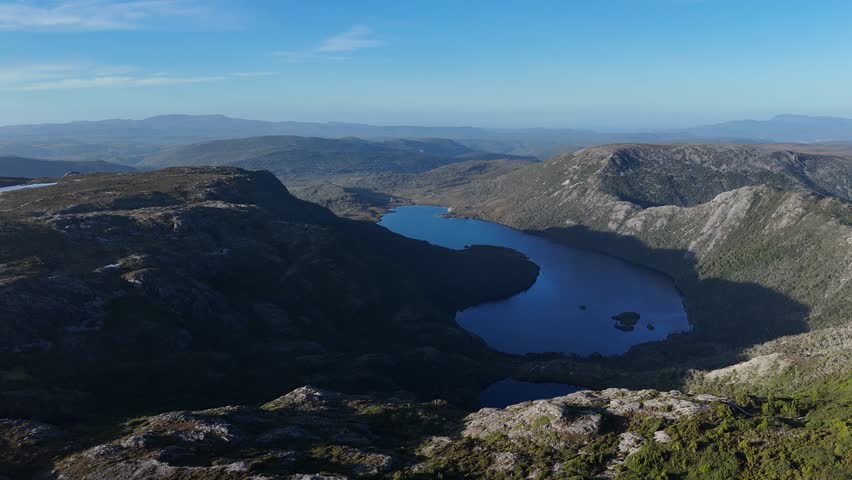 Dove Lake in valley between mountains of St Clair National Park during sunset. Tasmanian Landscape with Cradle Mountain, Australia. Drone wide shot.