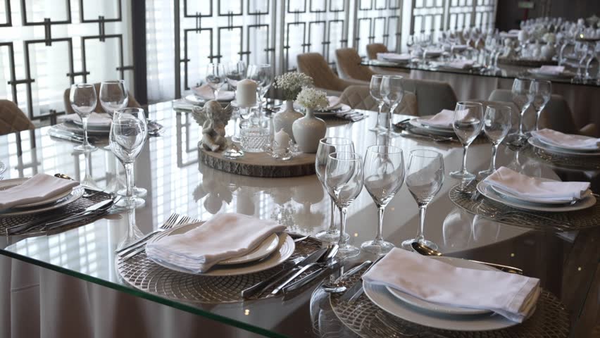 Elegant banquet setup with glass tables and fine dining décor in a modern interior