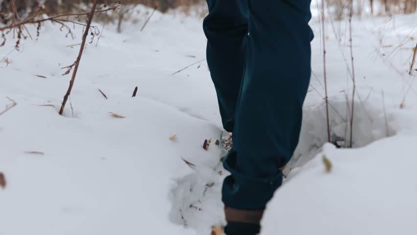Frozen Footprints An intimate view of a man feet leaving imprints on the snowy path, capturing the essence of a tranquil winter hike amidst nature