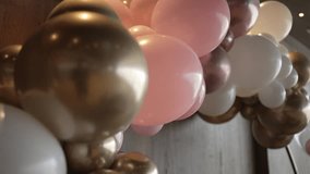 Close up of pink, gold, and white balloons forming a decorative arch in a festive setting - Powered by Shutterstock - Get 15% off with code: PIKWIZARD15
