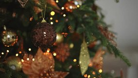 Merry Christmas Xmas happy holidays. Golden ornament decoration ball and defocused garland lights on classic decorated Christmas tree. Christmas tree with brown ornaments. Christmas eve at home - Powered by Shutterstock - Get 15% off with code: PIKWIZARD15