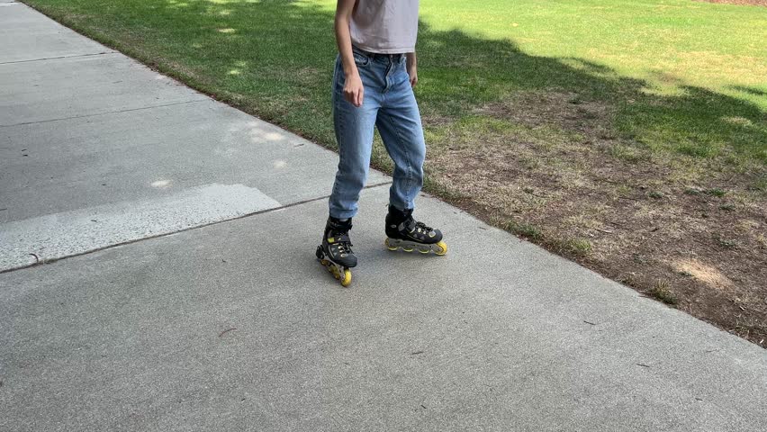 roller skates on the street. Closeup woman legs in blue jeans in roller blades is in action. legs of a person in the street.