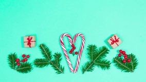 Gift boxes rotate around spruce branches, decorative red berries and heart-shaped candy canes. Beautiful Christmas greeting card. Merry Christmas. Turquoise background. Copy space. Stop motion animati - Powered by Shutterstock - Get 15% off with code: PIKWIZARD15